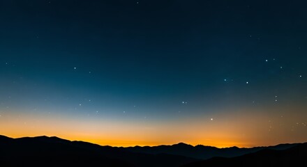 Fototapeta premium Vast starfield above silhouetted mountain range with golden twilight horizon