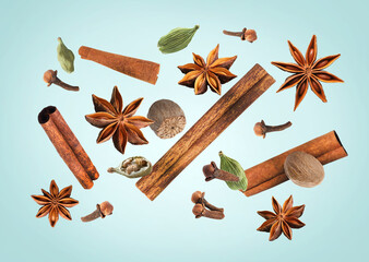 Christmas spices falling on light blue background