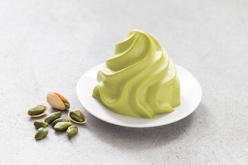 Vegan Pistachio cream dessert, Panna Cotta in the form of French Chantilly cream. Light background. Close up