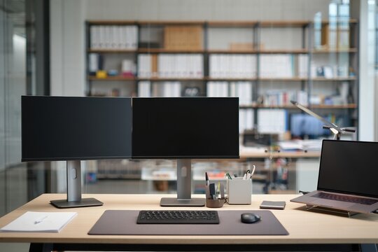 Close-facing view of a modern workstation with dual monitors and desk setup