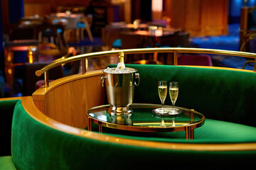 Obraz premium Luxurious nightclub VIP seating with plush green velvet, gold railing, and champagne