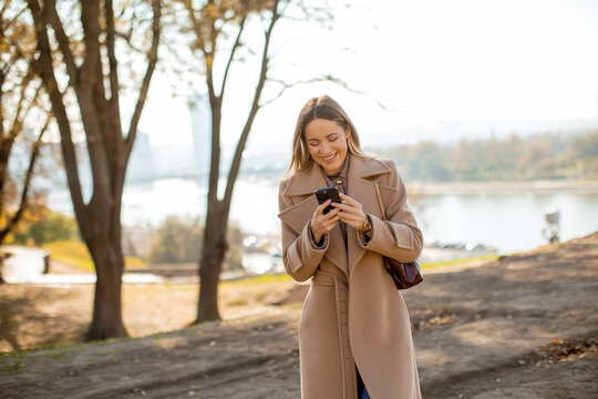 Woman enjoying a sunny day while texting on her smartphone in a park