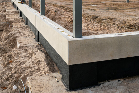 Concrete building foundation with waterproofing layer during early construction stage