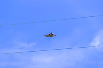 Photograph of a high-powered Jet aircraft flying at speed in regional Australia