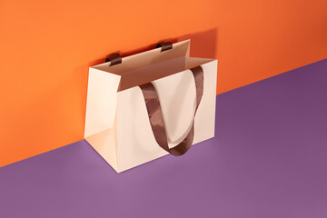 Beige paper glossy shopping bag mockup with brown handles

