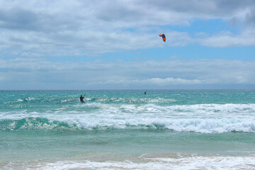 Kitesurfers Riding Waves at Sotavento Beach, Fuerteventura on a Sunny Day