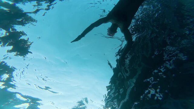 a man swimming in a pool, view from below