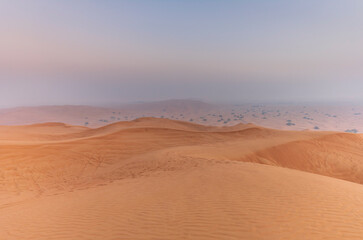The sun rising on the pristine and untouched red dunes in the desert near Dubai