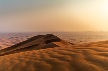 The sun rising on the pristine and untouched red dunes in the desert near Dubai