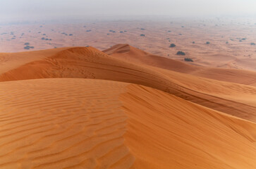 The sun rising on the pristine and untouched red dunes in the desert near Dubai