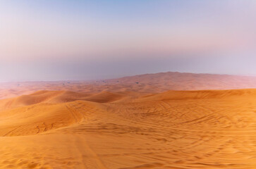 The sun rising on the pristine and untouched red dunes in the desert near Dubai