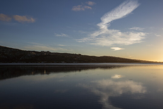 View of the serene water reflecting the sky and land, casting a tranquil spell over the landscape at sunset, Christchurch, Canterbury Region, New Zealand.