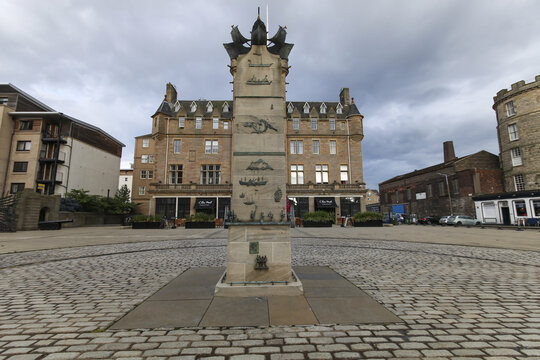 Edinburgh, United Kingdom - 23 June 2016: View of a tall monument with ship carvings standing grandly in a cobblestone square, framed by the ornate fa&Atilde;&sect;ade of The Malmaison hotel.