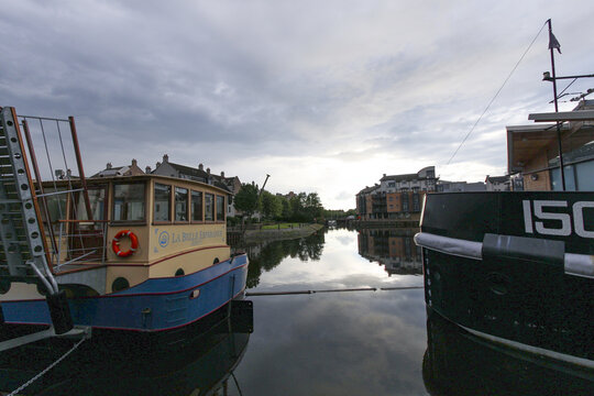 Edinburgh, United Kingdom - 23 June 2016: View of serene canal waters reflecting the buildings and boats, with the gentle ripples adding a touch of motion to the tranquil scene.