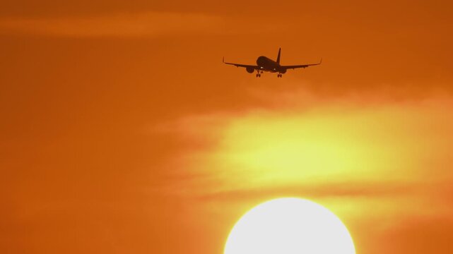 Airplane approaching landing against a golden sunset sky. Stunning travel and aviation background, perfect for tourism, airline, and commercial projects
