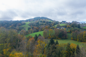 Obraz premium View from Schauinslandbahn cable car cabin on hills with wonderful autumn colors, beautiful forest and small villages, towns. Outdoor travel destination, black forest. Must-see hiking destination.