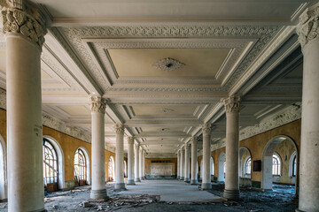 Fototapeta premium Abandoned neoclassical hall with marble columns and ornate ceiling, historic architecture with arched windows, retro textures, decay aesthetics and classical symmetry.