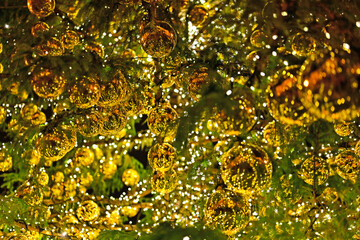 Golden shiny Christmas decorations on the Christmas tree close up, background