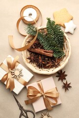 Christmas gifts, spices and festive decor on kraft paper background, flat lay