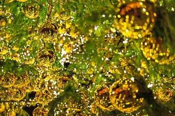 Golden shiny Christmas decorations on the Christmas tree close up