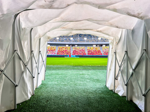 Massive Soccer Stadium tunnel.View of empty stadium. Green grass on a sport Arena. Empty Football Soccer Stadium Tribune. National arena with empty seats. Sport event on National Arena. 