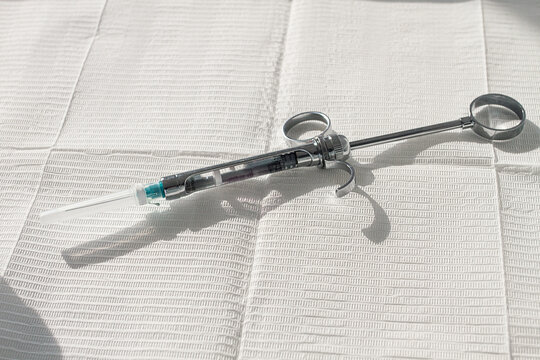 a carpal syringe, reusable, for use in dentistry, for the administration of anesthetic, lies on the table