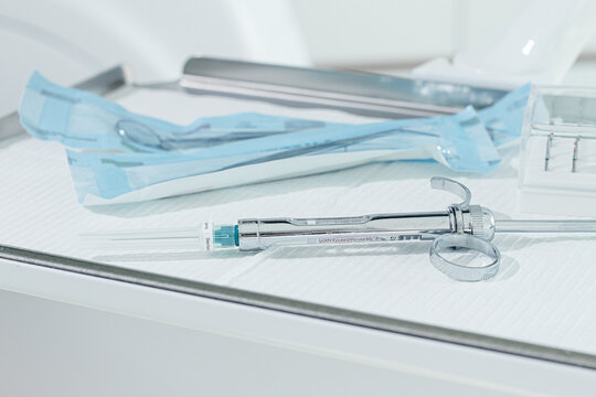 a carpal syringe, reusable, for use in dentistry, for the administration of anesthetic, lies on the table - Powered by Adobe