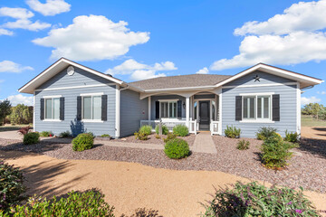 A charming blue house featuring white shutters adorning the windows