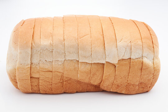 A small, freshly baked loaf of Jamaican sliced hard dough bread isolated on a white background