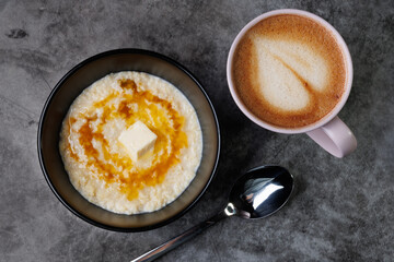 Creamy Oatmeal Breakfast Bowl With Butter, Syrup, And A Cup Of Coffee In A Pink Mug