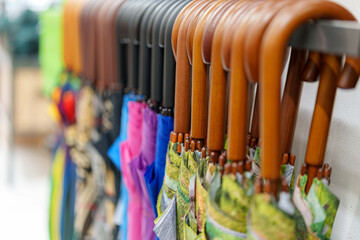 Rainy day rainbow a lineup of colorful closed umbrellas with wooden handles on display at a shop