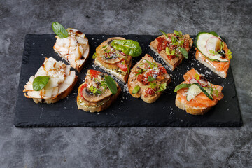 Assorted Gourmet Canaps On Black Slate Board for Elegant Party Platter and Tasting Experience