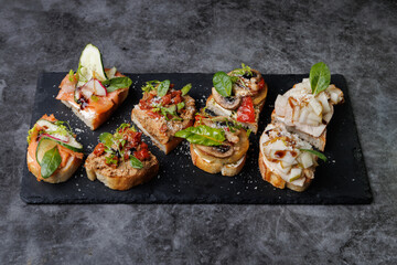 Assorted Gourmet Canaps On Black Slate Board for Elegant Party Platter and Tasting Experience