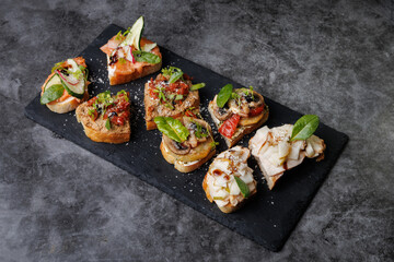 Assorted Gourmet Canaps On Black Slate Board for Elegant Party Platter and Tasting Experience