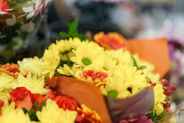 Blooming bright yellow chrysanthemums and vibrant roses create a colorful bouquet, perfect for a sunny afternoon