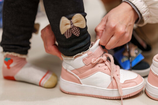 Little feet trying on new pink and white sneakers for a fun day out shopping at the Mall of America - Powered by Adobe