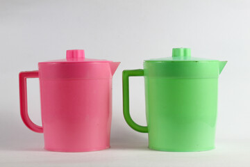 Delightful duo of pink and green plastic water pitchers, perfect for retro kitchen vibes or colorful product mockups and fun, vibrant summer designs.