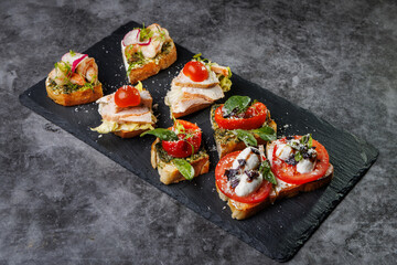 Assorted Crostini and Canap s on Slate Board Featuring Tomato, Cheese, Basil, and Seafood Toppings