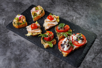 Assorted Crostini and Canap s on Slate Board Featuring Tomato, Cheese, Basil, and Seafood Toppings