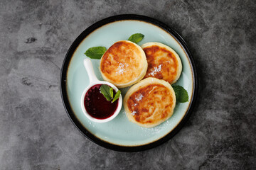 Golden-Brown Cottage Cheese Pancakes With Berry Sauce And Fresh Mint On A Plate For Breakfast Or Dessert