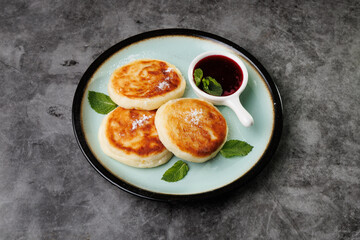 Golden-Brown Cottage Cheese Pancakes With Berry Sauce And Fresh Mint On A Plate For Breakfast Or Dessert