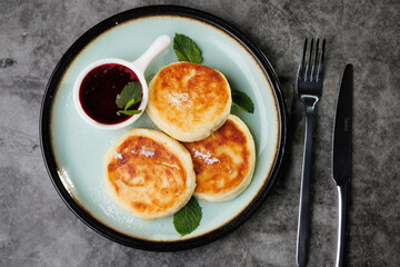 Golden-Brown Cottage Cheese Pancakes With Berry Sauce And Fresh Mint On A Plate For Breakfast Or Dessert