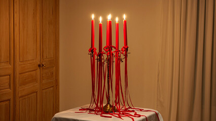 Elegant red candles burning brightly on a vintage gold candelabra, creating a warm and inviting atmosphere for intimate dinners and holiday celebrations