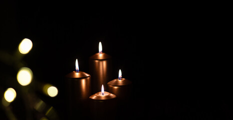 Burning Bronze Candles with Warm Bokeh Lights in Dark Festive Setting
