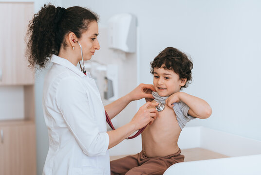 The doctor attentively listens to a child's lung sounds, creating a nurturing atmosphere in the pediatric clinic.