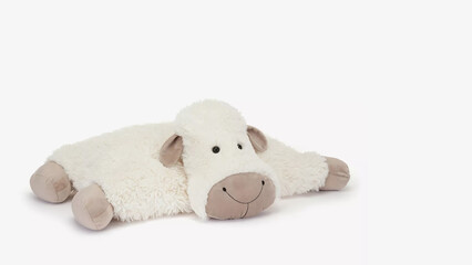 Fluffy sheep plush toy lying on a smooth surface, showcasing its cute face and soft texture in a cozy indoor setting.