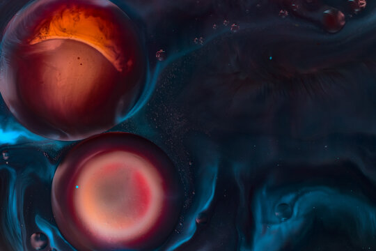 Macro abstract of circular fluid bubbles in vivid deep blue, red, and orange colors. Science-inspired molecular pattern, dark contrasted surface. Copy space