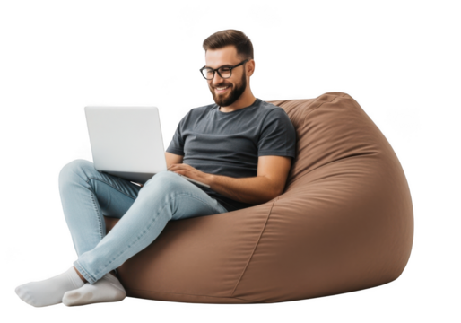 Young bearded man with glasses comfortably working on a laptop while sitting on a large brown bean bag chair
