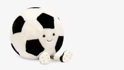 Soft soccer ball toy with a smiling face and cartoonish features on a plain background.
