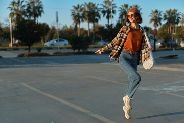 Woman jump in parking lot at golden hour, sunset smile and denim jeans with beanie and sunglasses; candid lifestyle moment with authenticity, golden hour glow, mindful living and emotional